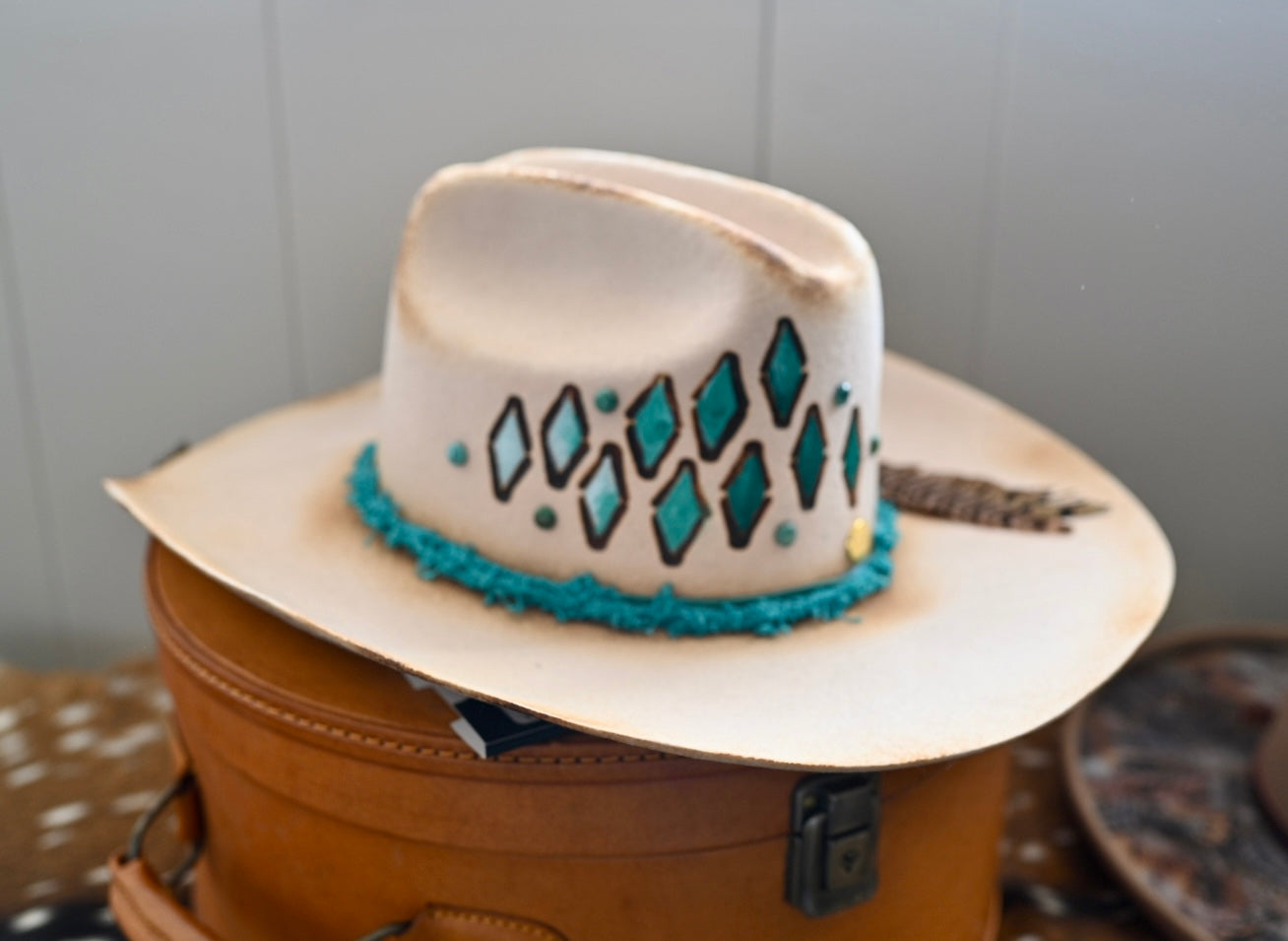 Ezra ivory felt cowboy hat with painted branding and Kingman turquoise accents.
