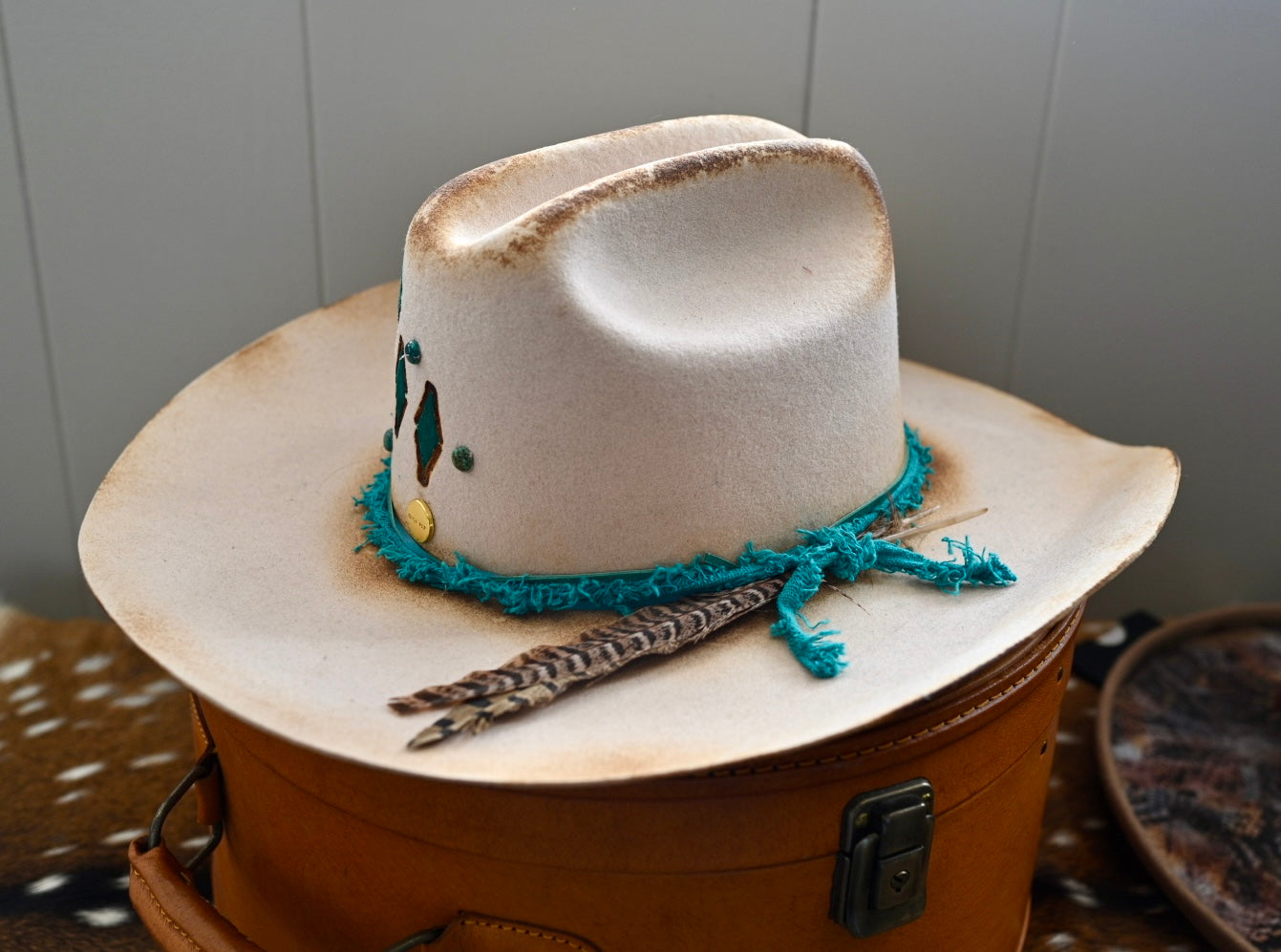 Ezra ivory felt cowboy hat with painted branding and Kingman turquoise accents.